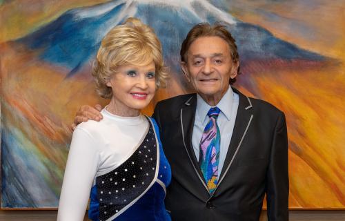 Charlotte Ginsburg, left, in white, blue and sequined outfit stands next to Allen Ginsburg, in black jacket and colorful tie