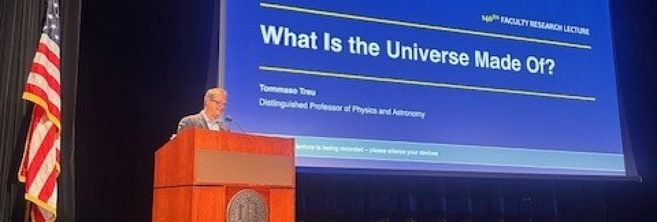Professor Tommaso Treu presenting PowerPoint at podium